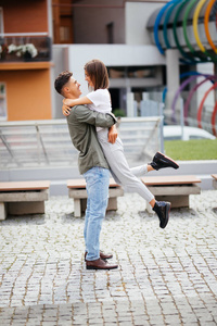 欣快的年轻夫妇，会议和在街上拥抱。在新人面带笑容爱站在街头的夏天