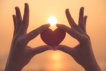 日落时手捧红心的特写和剪影心与手的剪影在日落背景的剪影手美丽的心