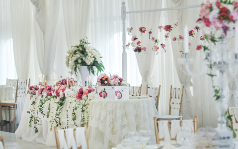 餐桌上的婚礼装饰。花卉安排和装饰。豪华婚礼活动中的粉红色和白色花朵的安排
