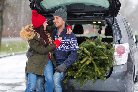 夫妇加载新鲜削减圣诞树回到他们的车