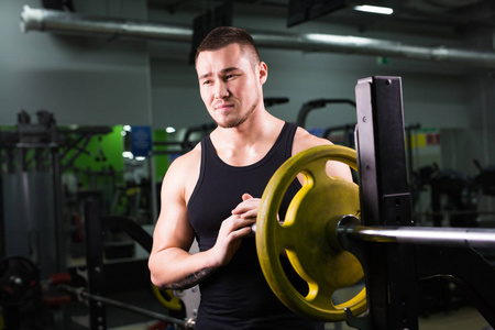 在体育馆举行磁盘权重的大肌肉的健康年轻人。健身 运动 训练 动机和生活方式的概念