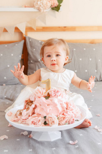 可爱的白种白人金发碧眼的女婴的肖像, 庆祝她的第一个生日。首页室内蛋糕粉碎第一年概念
