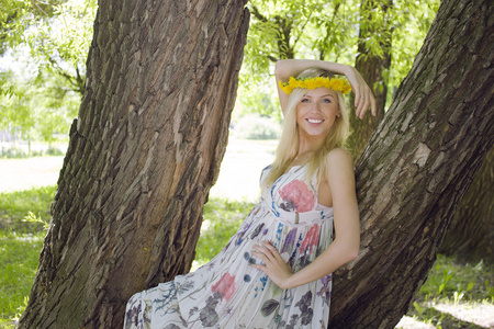 幸福的金发年轻女人微笑，花卉附近的公园里