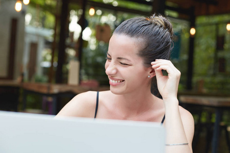 微笑满意女性的画像与朋友聊天在膝上型电脑的社交网络, 坐在舒适的