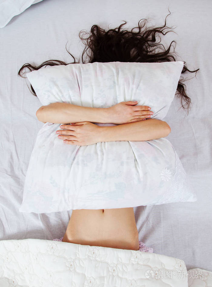 女孩在家睡在一张白色的床上.