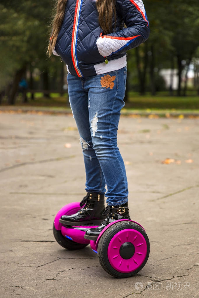 儿童平衡委员会.电动自平衡滑板车在城市街道.女孩学习骑板.