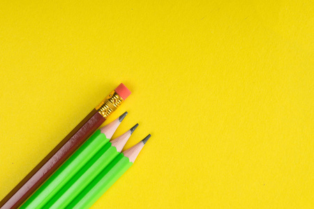商业概念许多相同的铅笔和一个不同的铅笔在黄纸背景。这是领导力的象征, 团队合作