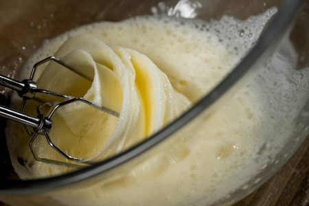用搅拌机和厨师手在玻璃碗里用面团鸡蛋面粉和配料来烹调木材背景