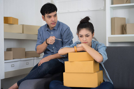 乏味的年轻妇女工作在顾客的包装期间, 浓度照片