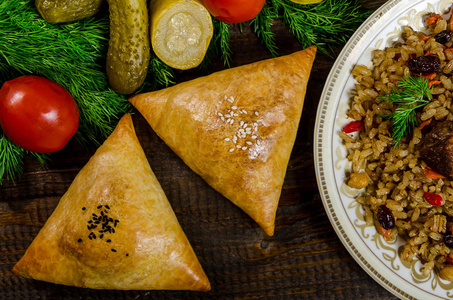 饭和萨姆沙在深色木 backgrou 上的乌兹别克民族菜肴