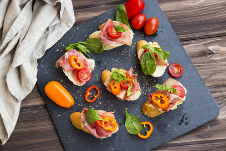 Bruschettas 或 crostini 的安排与火腿, 绿色 s