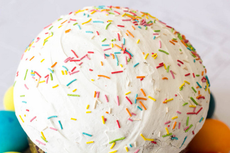 复活节蛋糕与糖衣结冰和复活节彩蛋在白色桌布背景