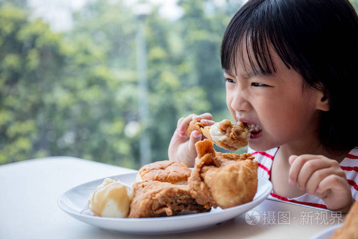 亚洲的中国小女孩吃炸鸡