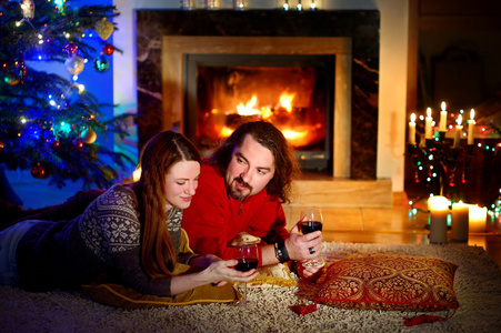 对夫妇躺在壁炉旁在圣诞平安夜