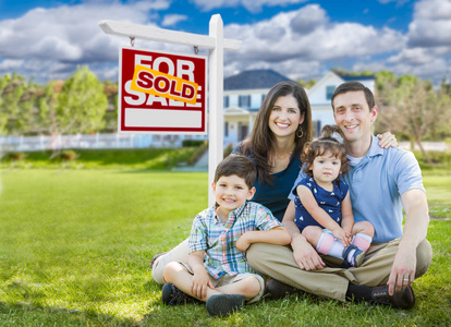 年轻的家庭，孩子们在自定义主页和卖出售房地产标志