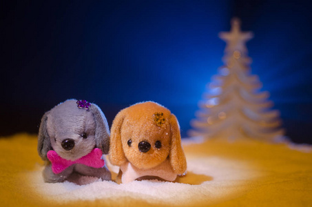 玩具狗象征着新的一年在雪下的冷杉树枝的背景。玩具的狗作为象征2018年新年与圣诞节属性新年题词