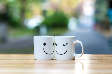 与背景虚化,关于恋爱观的木桌上的两个快乐杯照片