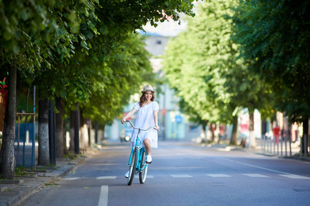 夏天的时候, 年轻女子骑着复古的自行车上路。
