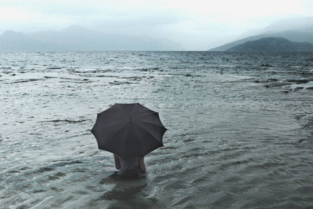 孤独的女子等待雨坐在海中的伞