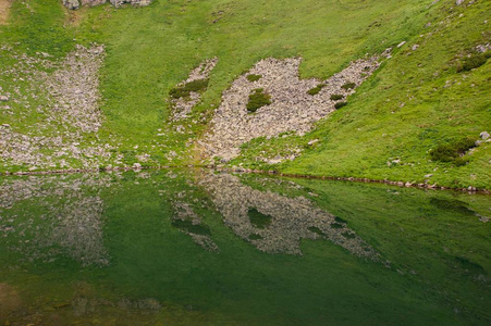 一只抽象的蝴蝶惊人的拍摄岩石山和它的倒影在山上的湖泊, 使一个美丽的蝴蝶形状