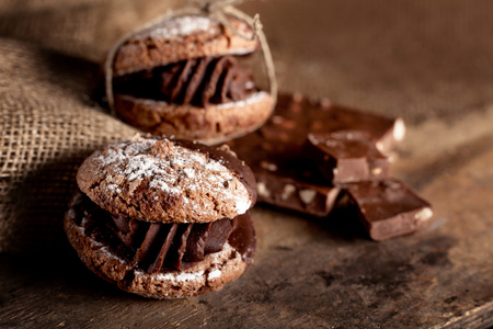 巧克力饼干和一块块巧克力放在旧木制的背骨上