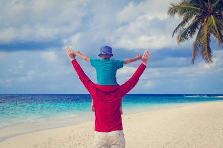 快乐的父亲和儿子在海边度假图片