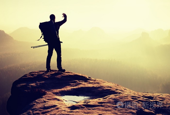徒步旅行者在山峰上背包客与两极牵手遮蔽眼睛春天的黎明