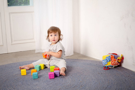 小快乐的女孩在地板上玩玩具