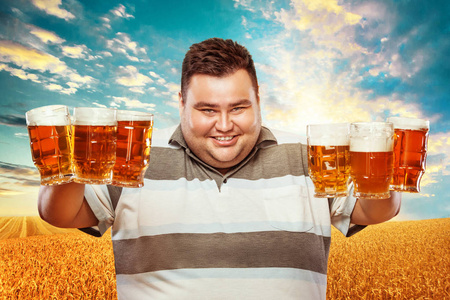年轻的胖男人在慕尼黑啤酒节，在黄色背景上喝啤酒
