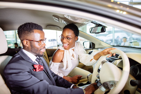 美丽的非洲夫妇正在选择新的汽车经销商