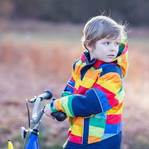 孩子安全头盔和 outd 多彩雨衣骑自行车的男孩