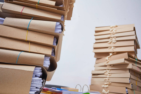 成堆的纸质档案将文件文件堆放在档案文件中,办公室办公桌上有回形针