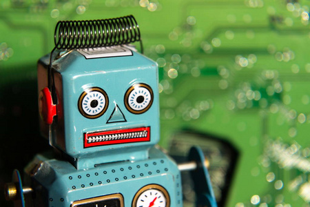 老式锡玩具机器人与绿色计算机电路板背景, 人工智能概念