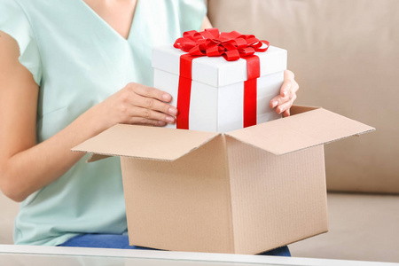 妇女收到礼物在包裹盒在家里照片