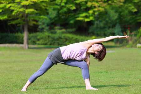 日本女人外面做瑜伽三角伸展式