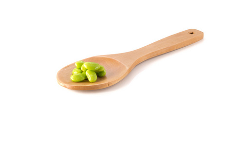 绿色大豆，白色背景上的木勺子
