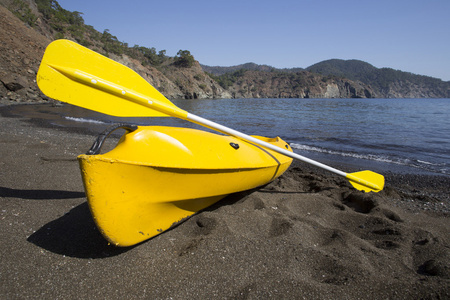 Kayak 是在山上的背景下的海滩上