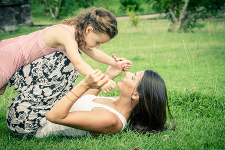 母亲和女儿在一天时间在草地上玩耍