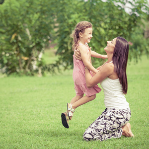 幸福的母亲和女儿在一天时间在公园里玩