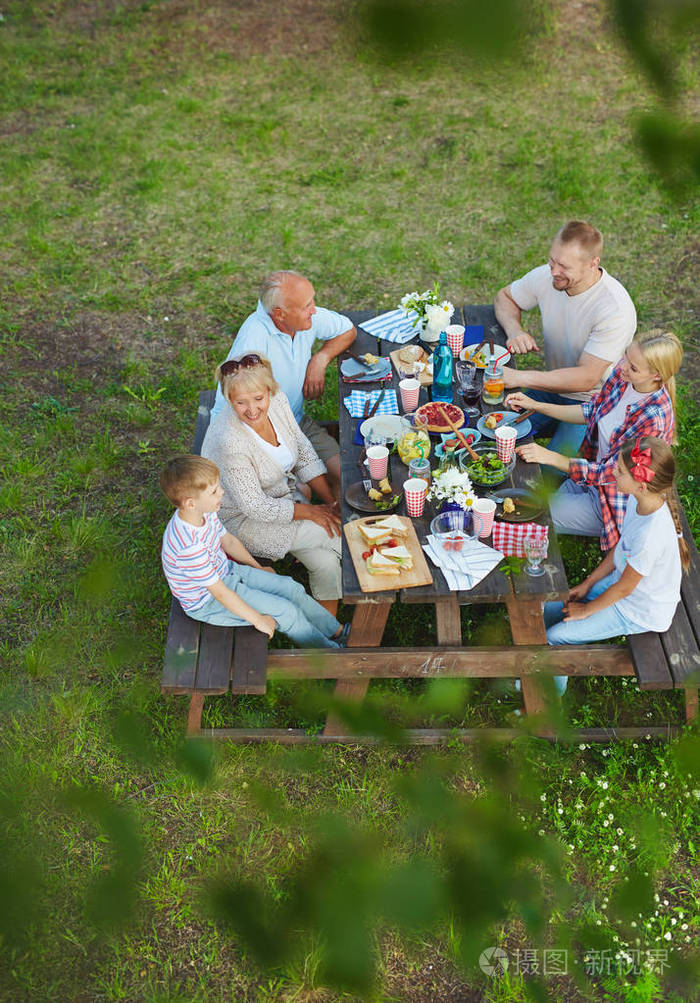 愉快的家庭坐在桌上在夏天天