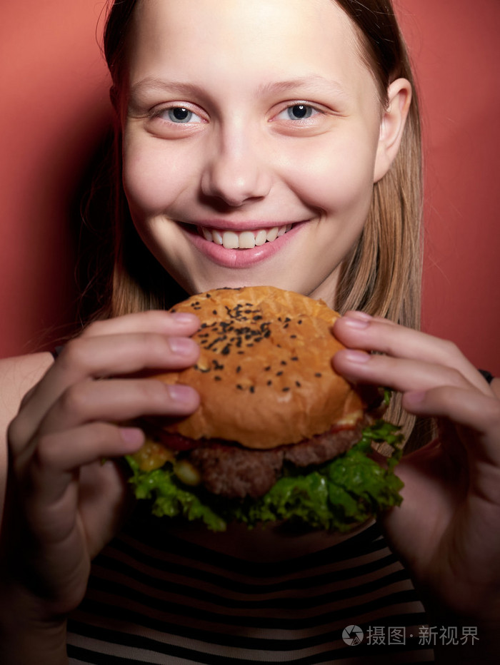 十几岁的女孩吃一个汉堡