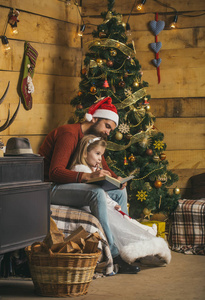 圣诞节快乐的人和小女孩读书