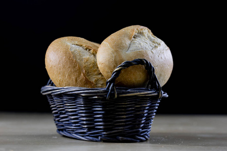 美味的新鲜面包在柳条篮子。在一个篮子里滚进一只小宇