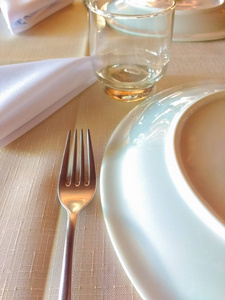 亚麻桌布, 准备晚餐与叉子, 玻璃, 盘子和餐巾, 在柔和的灯光下餐厅