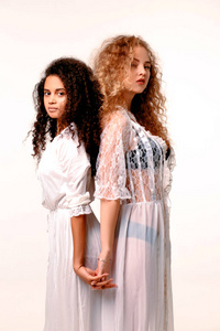 两个美丽温柔的女孩在丝绸 peignoir。非洲和金发