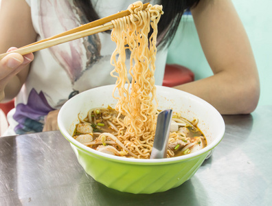 女人在一个碗里吃面条侧重面照片