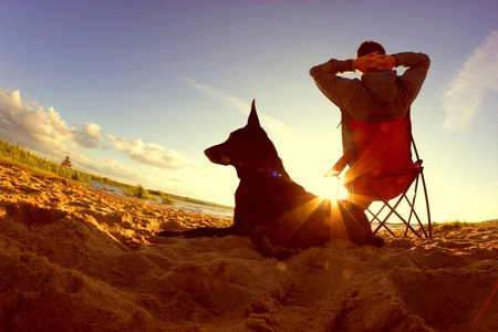 男人和他的狗在沙滩上放松