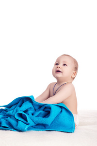 可爱的宝宝坐在蓝色毛巾被毯