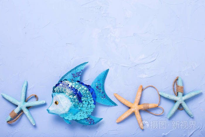 装饰鱼和蓝带纹理的背景上的海洋项目。选择性的焦点。文本的地方
