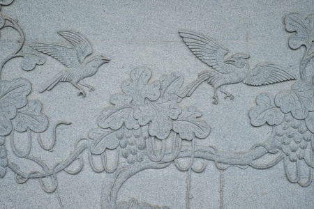 刻在石头墙在华人庙宇的鸟图片